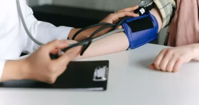 Healthcare worker monitoring blood pressure.