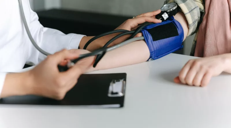 Healthcare worker monitoring blood pressure.